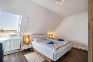a bedroom with a white bed and a window at Ferienwohnung Luna in Bindlach +23 photos