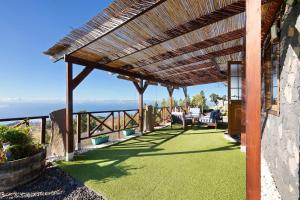 a patio with a roof with a view of the ocean at Media Pipa in Puntagorda