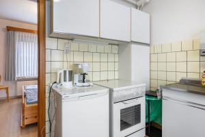 a kitchen with white appliances and white cabinets at Haus Lahrsen in Wesselburen