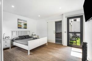 a white bedroom with a bed and a mirror at Casita El Pleito in Candelaria +21 photos