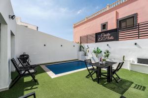 a patio with a table and chairs and a swimming pool at Casita El Pleito in Candelaria