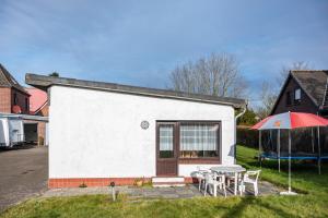 a small house with a table and an umbrella at Haus Lahrsen in Wesselburen