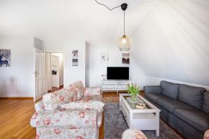 a living room with a couch and a tv at Ferienwohnung Gestüt Kriseby in Lübeck