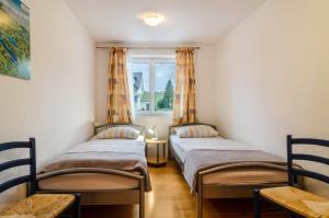 two twin beds in a room with a window at Apfel in Meersburg