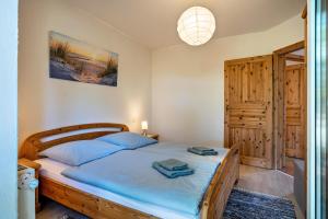 a bedroom with a wooden bed with blue sheets at Hof Verchen Nahe Kummerower See in Verchen