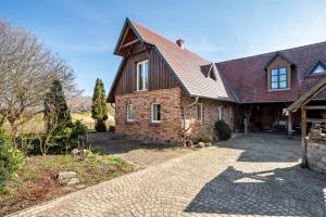 a brick house with a gambrel roof and a driveway at Hof Verchen Nahe Kummerower See in Verchen