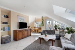 a living room with a couch and a tv at Ferienhaus Lydia in Sasbach in der Ortenau