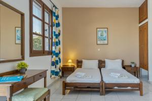 a bedroom with a bed and a desk and window at Frantzis studio 3 Nisyros in Páloi