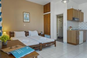 a bedroom with a bed and a table and a kitchen at Frantzis studio 3 Nisyros in Páloi +20 photos