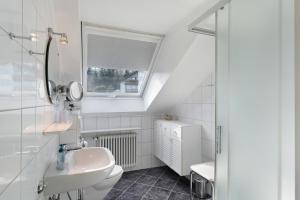 a white bathroom with a sink and a toilet at Ferienhaus Lydia in Sasbach in der Ortenau +55 photos