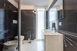 a bathroom with a sink and a toilet and a mirror at Olimar Home in Santa Flavia +17 photos
