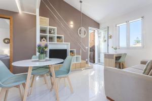a dining room and living room with a table and chairs at Olimar Home in Santa Flavia