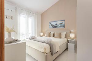 a white bedroom with a large bed and a window at Olimar Home in Santa Flavia