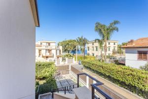 a balcony with chairs and trees and buildings at Olimar Home in Santa Flavia