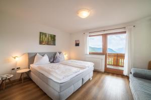 a bedroom with a bed and a large window at Hotel Klausthaler in Meltina +69 photos