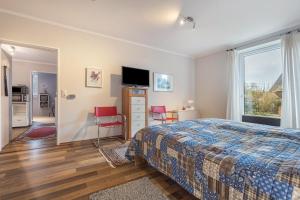a bedroom with a bed and a tv and a window at Haus Erika in Brunsbüttel