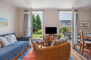 a living room with a couch and chairs and a tv at Haus Erika in Brunsbüttel