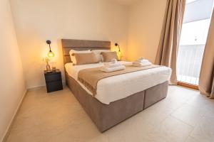 a bedroom with a large bed with towels on it at Kožino Bay Lodge - Brand New Seaside Apartments, Heated Pool in Kožino +79 photos