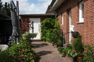 a brick house with an umbrella and some plants at Haus Schulz in Heide