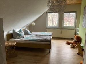 a bedroom with a bed and a teddy bear on the floor at Ferienwohnung Wie zu Hause in Ostritz