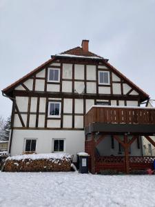 a house with snow on the ground in front of it at Ferienwohnung Wie zu Hause in Ostritz