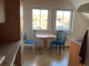 a small kitchen with a table and two chairs at Ferienwohnung Wie zu Hause in Ostritz
