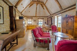 a living room with red chairs and a table at Chez Jacquou in Bouniagues