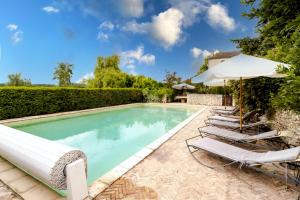 a swimming pool with lounge chairs and an umbrella at Chez Jacquou in Bouniagues