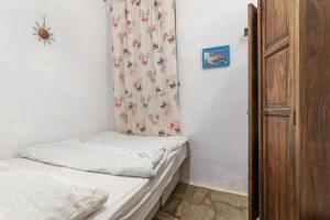 a small bedroom with two beds and a spider on the curtain at Kykladen White House in Koumáros