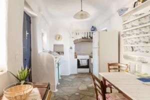 a kitchen and dining room with a table and chairs at Kykladen White House in Koumáros