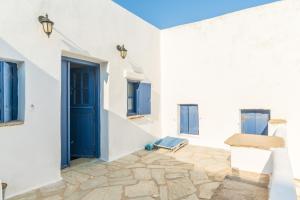 a room with white walls and a blue door at Kykladen White House in Koumáros