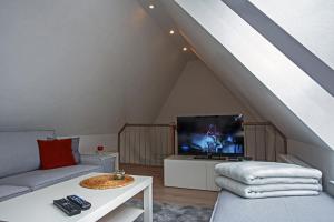 a living room with a couch and a tv in an attic at Haus Schulz in Heide