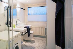 a bathroom with a sink and a toilet and a window at Haus Schulz in Heide +39 photos