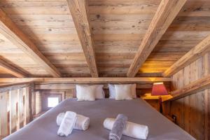 a bedroom with a bed in a wooden cabin at Mazot des aravis in Combloux