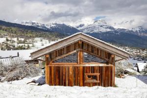 a small wooden building in the snow with mountains at Mazot des aravis in Combloux +4 photos