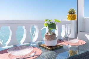 a table with two glasses and a potted plant on it at Casacamer S in Sagunto