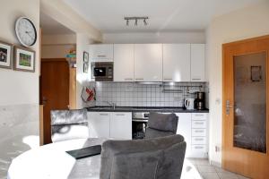 a kitchen with white cabinets and a table and chairs at Ferienwohnung Tannenblick 8-1 in Oberhof