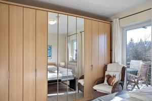 a bedroom with a mirror and a chair and a bed at Ferienwohnung Tannenblick 8-1 in Oberhof