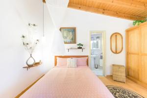 a bedroom with a pink bed in a room at Casa Cisne - Selão da Eira in São Miguel +23 photos