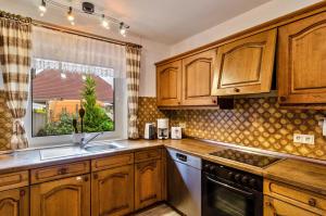 a kitchen with wooden cabinets and a window at Haus Störtebeker in Marienhafe +15 photos