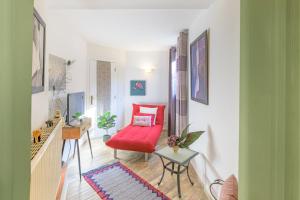 a living room with a red couch and a table at Casa Cisne - Selão da Eira in São Miguel