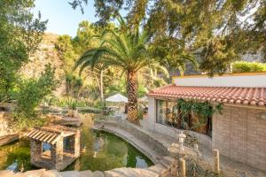 a house with a pond in a garden at Casa Cisne - Selão da Eira in São Miguel