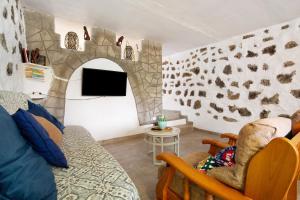 a living room with a couch and a tv at Alma Eco-rústico Adults Only in El Charco
