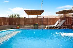 a swimming pool with a chair and an umbrella at Alma Eco-rústico Adults Only in El Charco