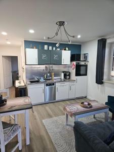 a kitchen with white cabinets and a living room at Ferienwohnung - Wolkow in Wolkow