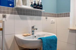 a bathroom with a sink and a blue towel at Ferienwohnung - Wolkow in Wolkow