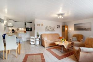 a living room with couches and a table and a kitchen at Ferienwohnung Landhaus Loose in Schashagen