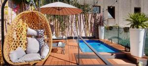 a swinging chair with an umbrella next to a pool at Mansarda con vista lago in Sulzano