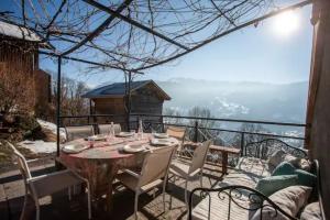 a table and chairs on a balcony with a view at L'échappée des Rêves in Verchaix