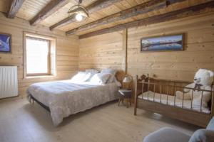 a bedroom with a bed in a wooden room at L'échappée des Rêves in Verchaix